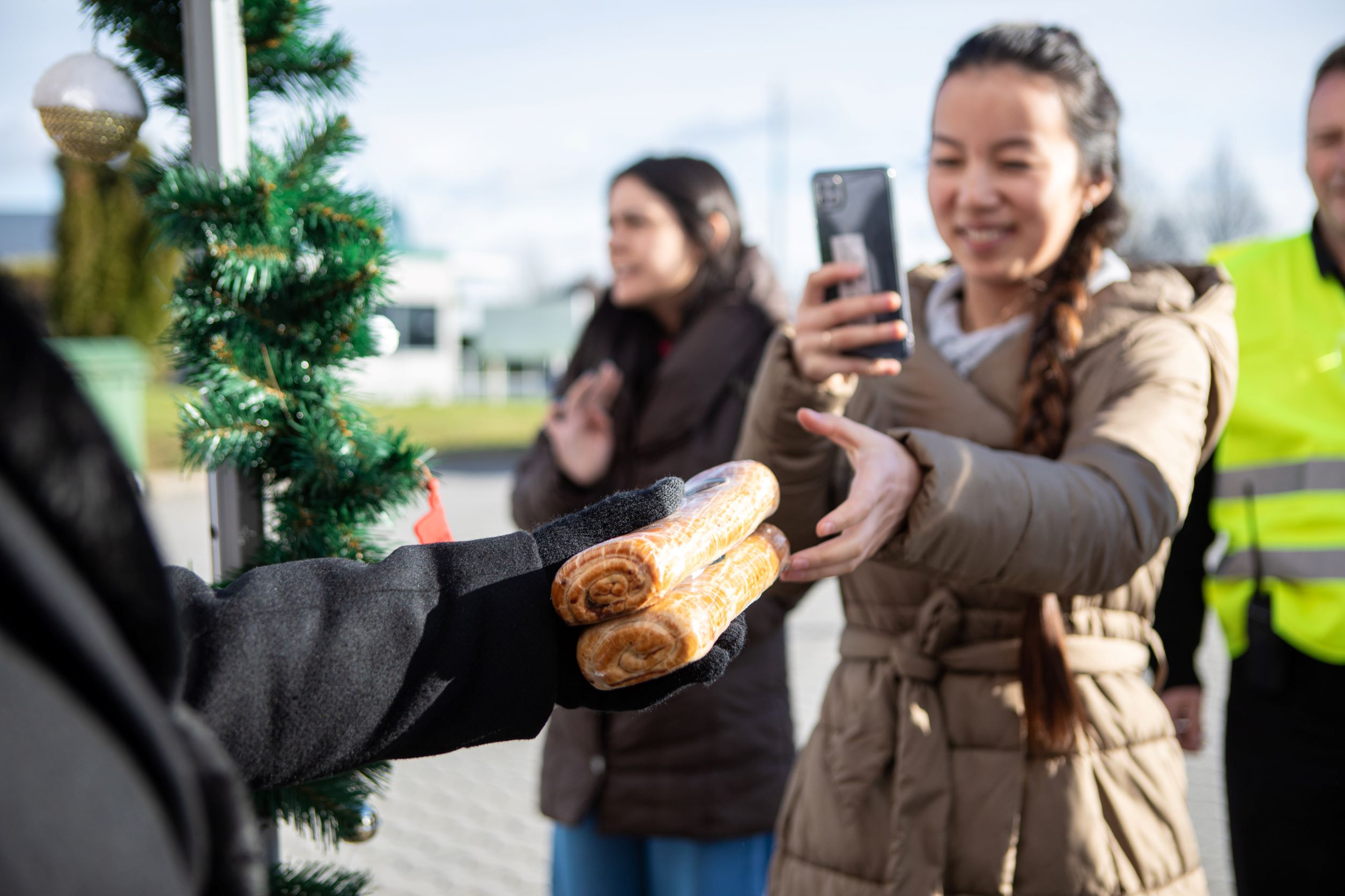 Girl with a phone receiving holiday pastries